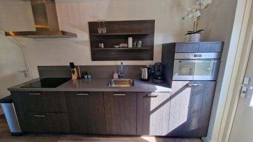 a small kitchen with a sink and a stove at B&B De Droomhoeve in Nunspeet