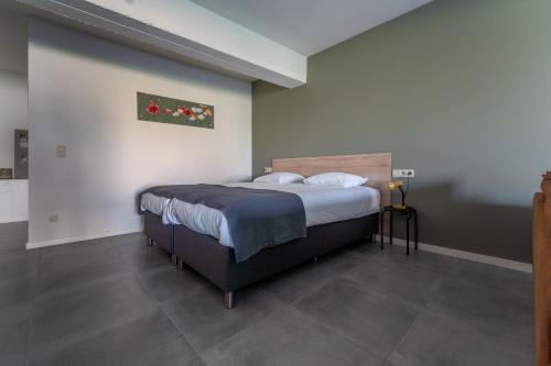 ein Schlafzimmer mit einem großen Bett in einem Zimmer in der Unterkunft De Hoog Velden 11 in Neerpelt