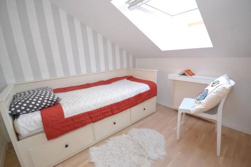 een slaapkamer met een bed en een stoel en een dakraam bij Villa Magalia in Bol