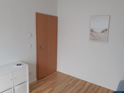 Habitación con puerta y suelo de madera. en Schönes Zimmer in der Wetterau, en Ranstadt