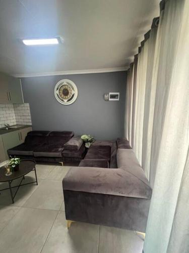 a living room with a couch and a window at Ubuntu Lifestyle Estate - Nkandla DeLux in Krugersdorp