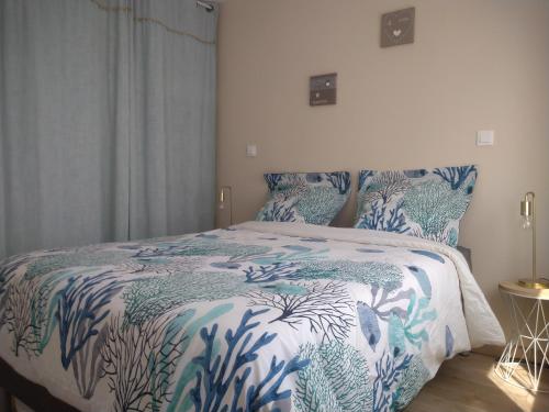 een slaapkamer met een bed met een blauw en wit dekbed bij T2 charmant bord de mer Pornichet avec terrasse in Pornichet