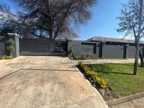 un bâtiment avec une clôture et un arbre dans une cour dans l'établissement Ubuntu Lifestyle Estate, à Krugersdorp