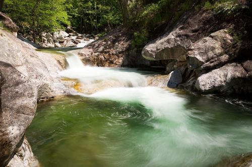 a stream of water in a river with rocks at Appartement sur Vals les bains in Vals-les-Bains