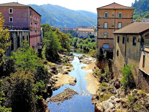 a view of a river in a city with buildings at Appartement sur Vals les bains in Vals-les-Bains
