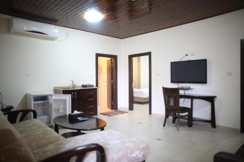 a living room with a couch and a table and a tv at Bab Al Shams Resort in Jericho