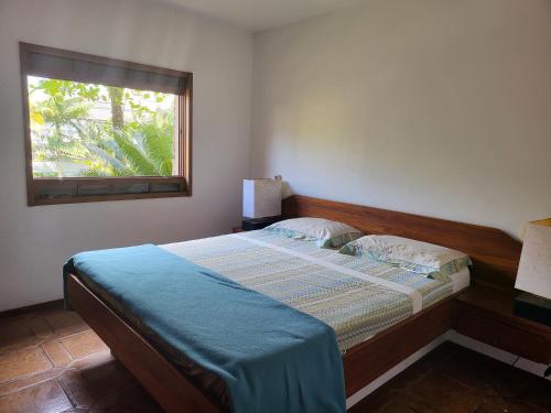 a bedroom with a large bed with a window at Green Toque-Toque in São Sebastião