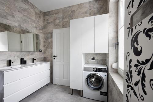 a white laundry room with a washing machine and a sink at Vila Mignon in Bled