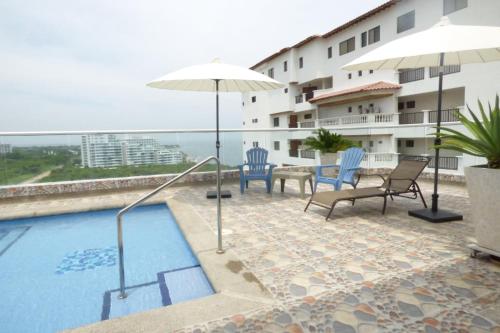un hotel con piscina, sillas y sombrilla en Bello Horizonte * Unido Al Mar, en Santa Marta