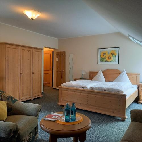 a bedroom with a bed and a table with bottles on it at Berggasthof Koitsche im Naturpark Zittauer Gebirge in Bertsdorf