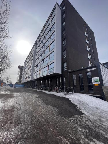 a large building with bikes parked outside of it at Kotimaailma Apartments - Madetojanaukio in Oulu