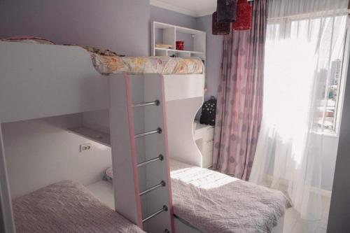 a bedroom with two bunk beds and a window at Family apartment in Batumi