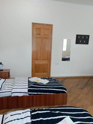 a room with two beds and a door in it at Art House Hostel Aleksandr in Kutaisi