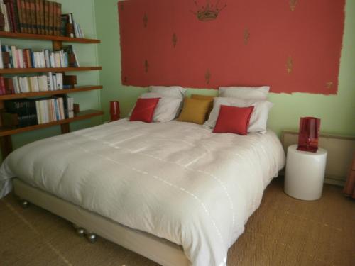 a bedroom with a large white bed with colorful pillows at Face au Sancy in Aydat