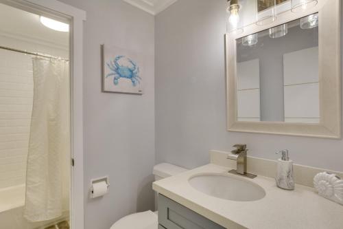 a bathroom with a sink and a toilet and a mirror at Modern Delray Home about 3 Mi to Town 4 Mi to Beach! in Delray Beach