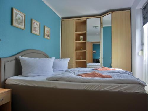- une chambre avec un grand lit et un miroir dans l'établissement Ferienwohnung N29, à Graal-Müritz