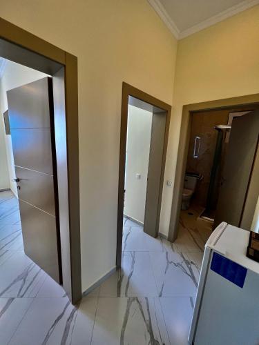 an empty room with two doors and a bathroom at Oscar’s Apartments Drymades in Dhërmi