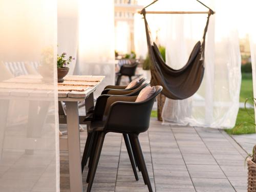 a hammock hanging from a table and chairs on a patio at KOMFORTOWE DOMKI Brzozowa Przystań nad morzem we Władysławowie in Władysławowo