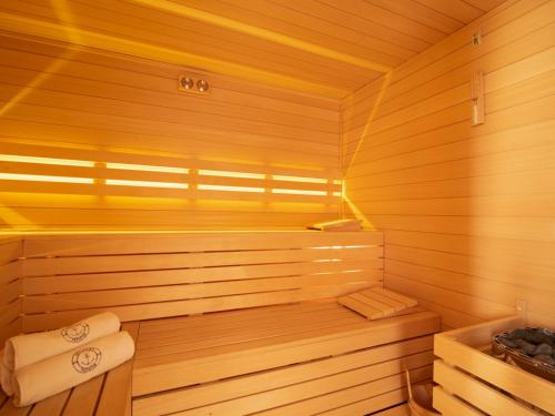 a wooden sauna with a bench and a tub at KOMFORTOWE DOMKI Brzozowa Przystań nad morzem we Władysławowie in Władysławowo