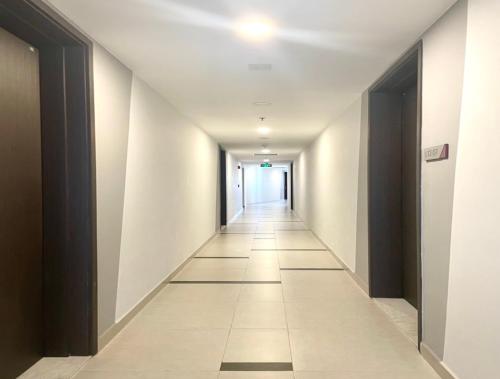 un pasillo con paredes blancas y un pasillo largo en Compass One Building - Luxury Apartments en Ấp Phú Thọ