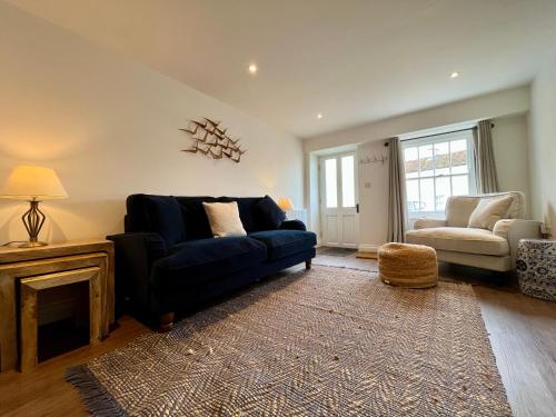 a living room with a blue couch and a chair at Wesley Cottage in Middleham