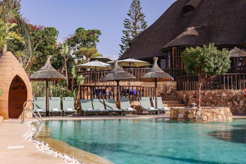a pool at a resort with chairs and umbrellas at Desert Springs Resort in Vera
