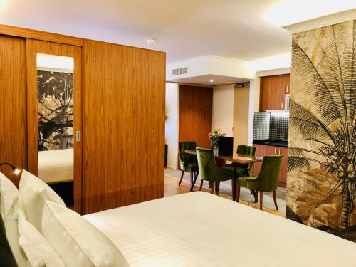 um quarto de hotel com uma cama, uma mesa e cadeiras em Chassé Hotel Residency em Amsterdã