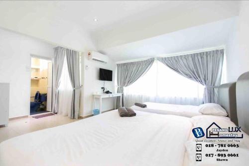 a bedroom with a large white bed and a window at Cozy 6BR Gurney GeorgeTown Homestay in Tanjung Bungah