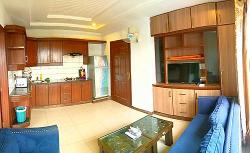 een woonkamer met een blauwe bank en een keuken bij Comfortable Rental Apartments In Bahria Town in Rawalpindi