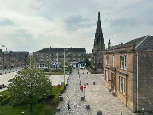 a group of people walking down a street in a city at Rooms Above Sugar Boat in Helensburgh