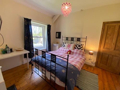 a bedroom with a bed and a chandelier at Homecroft in Saundersfoot