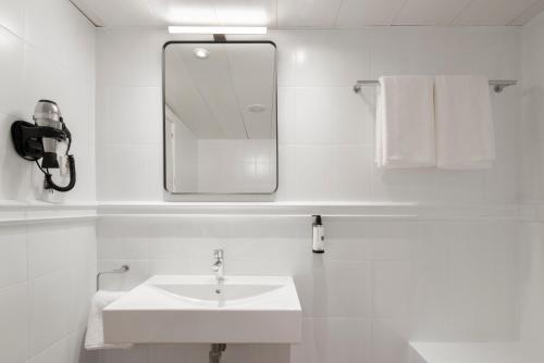 a white bathroom with a sink and a mirror at H Regas Adults Only in Barcelona