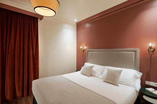 a bedroom with a large bed with white pillows at H Regas Adults Only in Barcelona