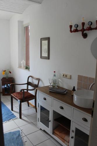 a bathroom with a sink and a table and a chair at Pension Burgenring in Schlitz