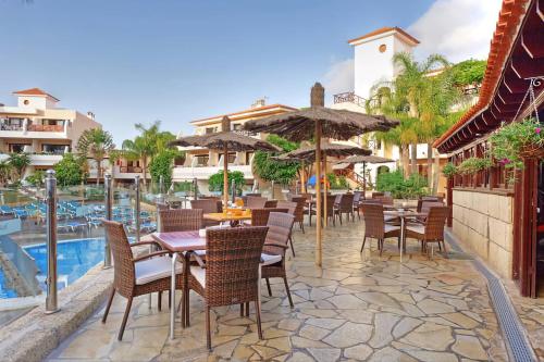 サンミゲル・デ・アボナにあるGolf del Sur Park Albatrosのプールサイドのレストラン(テーブル、椅子付)