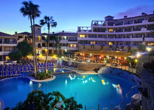 サンミゲル・デ・アボナにあるGolf del Sur Park Albatrosの夜間のプール付きのホテルの景色を望めます。