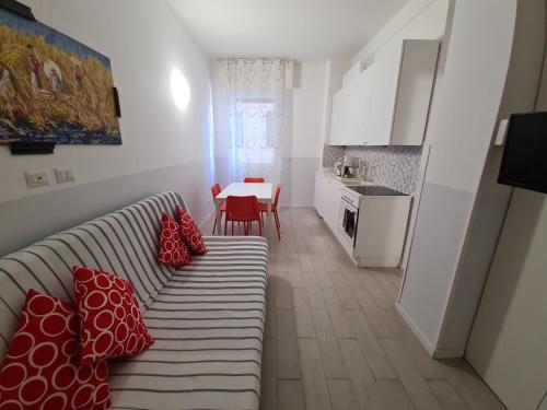 un soggiorno con divano e cuscini rossi sopra di La Casa di Sandra by PortofinoVacanze a Rapallo