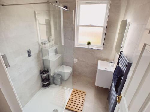La salle de bains est pourvue d'une douche, de toilettes et d'un lavabo. dans l'établissement Tynemouth Seaside 3 Bed House Close to Beach/Bars/Restaurants - Parking Space Included, à Tynemouth