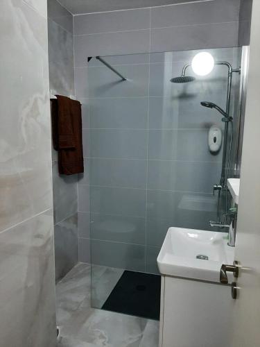 y baño con ducha y lavabo blanco. en Casa da Praia, en Armação de Pêra