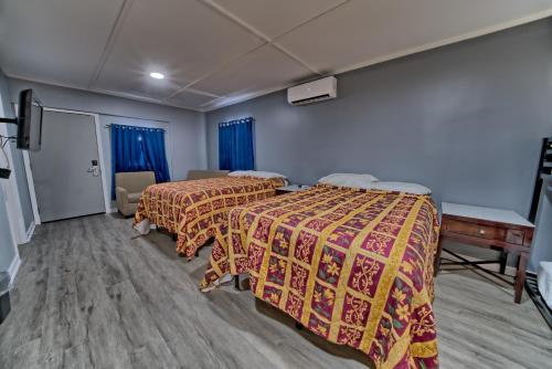 two beds in a room with blue walls and blue curtains at Aqua View Motel in Panama City Beach