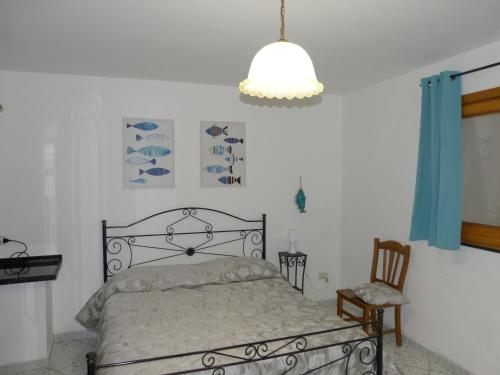 1 dormitorio con 1 cama y luz colgante en Casa Vacanze Vincenzo e Rosanna, en Castro di Lecce