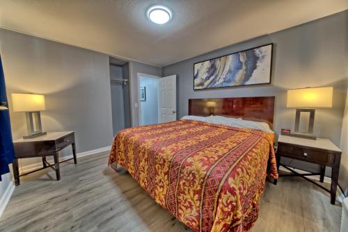 a hotel room with a bed and two night tables at Aqua View Motel in Panama City Beach