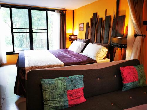 sypialnia z łóżkiem i kanapą w obiekcie Brookhouse at Khaoyai w mieście Ban Khanong Phra Klang (1)