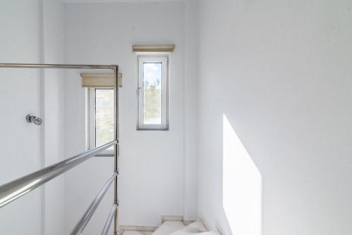 a staircase in a white room with a window at Villa Olive with Pool & SeaView in Agia Pelagia