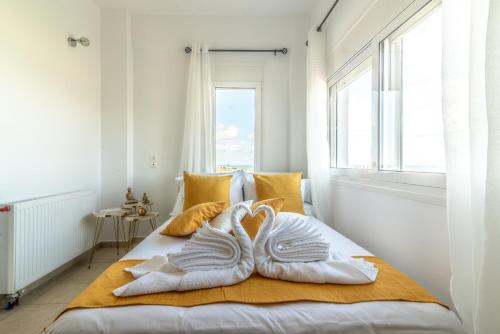 a bedroom with towels on a bed with a window at Villa Olive with Pool & SeaView in Agia Pelagia