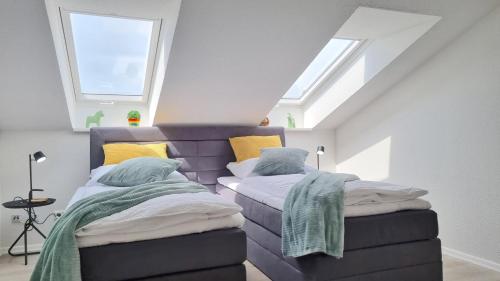 two beds in a attic room with two windows at Wohnung: Workaholic bis 6 Personen, Klima, 3x TV in Cremlingen