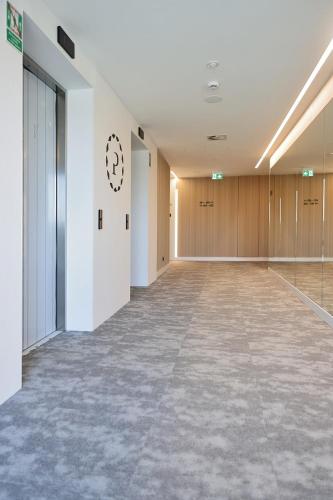an empty hallway of a building with a large room at Pinea Apartments in Pobierowo