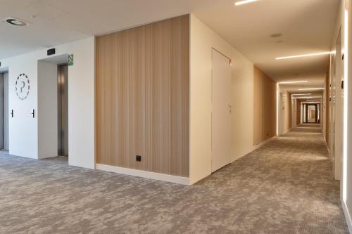 an empty corridor of an office building with wooden walls at Pinea Apartments in Pobierowo