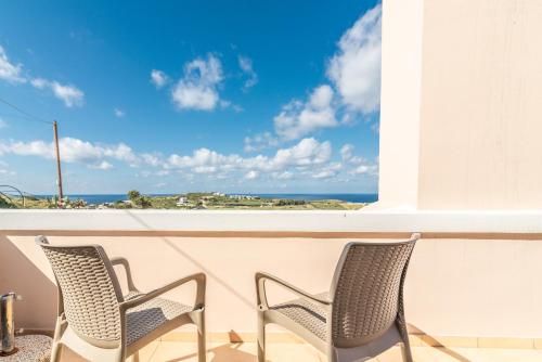 two chairs on a balcony with a view of the ocean at Villa Olive with Pool & SeaView in Agia Pelagia