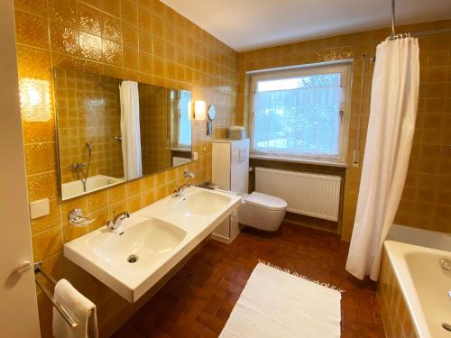 a bathroom with a sink and a toilet and a mirror at Haus Irmgard in Bad Endorf